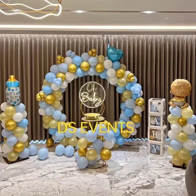 A classic "It's a Boy" baby shower theme. This setup includes a full balloon ring in blue and gold, themed props like a baby bottle balloon pillar, and "BABY" display boxes for a complete and joyful look.