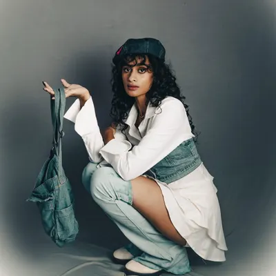 A cool, urban-inspired studio shoot. The simple grey background puts all the focus on the model's attitude and the layered denim styling.
