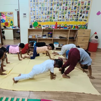 Our little Asters practice their plank and downward dog poses during a group yoga session. We make fitness fun by incorporating playful movements and poses.