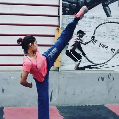 Flexibility is key to powerful kicks. One of our dedicated female students demonstrates a perfect high kick, showcasing the incredible physical conditioning and technique developed through our training programs.