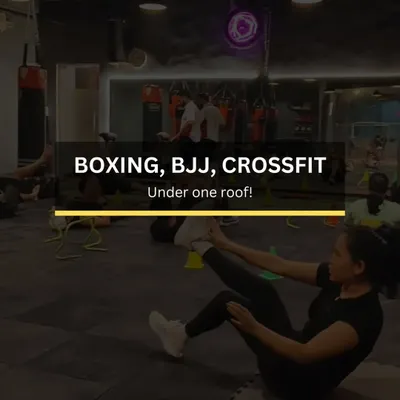 Boxing, BJJ, CrossFit. All under one roof. This image captures the essence of our gym, where a member is working on core strength while others train in the background. We build real strength, agility, and resilience.