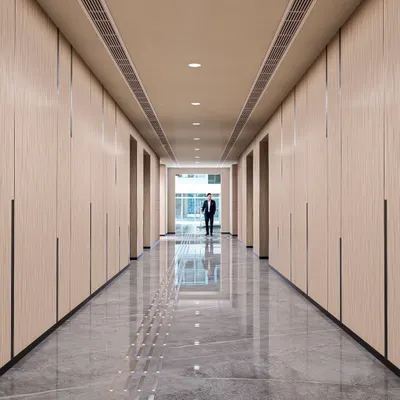 The elevator lobby at Brookfield, Candor TechSpace, designed for a feeling of contemporary elegance. The wood-paneled walls, polished marble floors with tactile paving, and clean lines create a sophisticated and seamless transition space.
