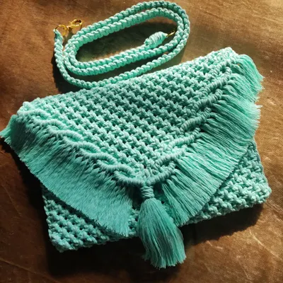 This mint green macrame sling bag is a perfect mix of craftsmanship and modern aesthetics. It's stylish, functional, and handmade with intricate detail.