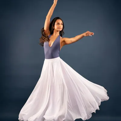 A studio portrait capturing the feeling of a 'swan song' through movement. The flowing skirt and graceful lines create a sense of elegance and flight.