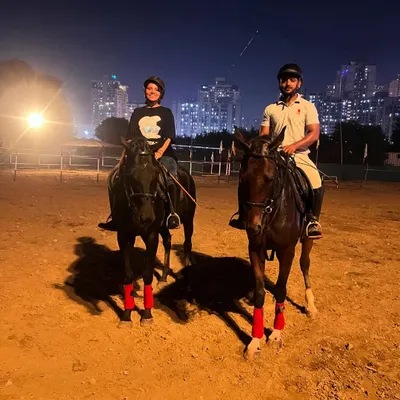 Two riders enjoy a night session in our well-lit arena, with the city lights providing a stunning backdrop.