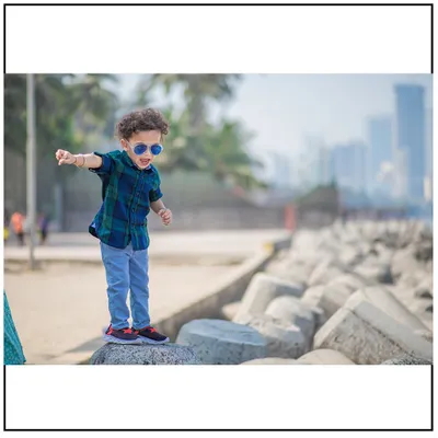 This little explorer is confidently navigating the rocks at the Mumbai seafront. Outdoor toddler photography is all about capturing their sense of adventure.
