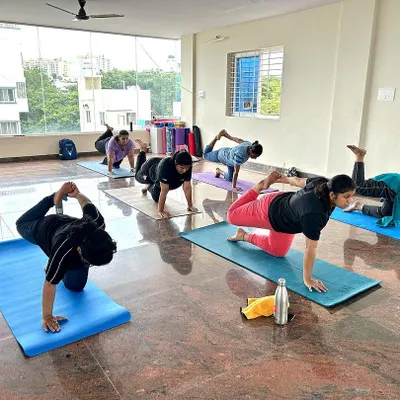 Students in our Bangalore studio moving through a balancing sequence. Each person is focused on their own practice, finding stability and strength in this dynamic kneeling pose.