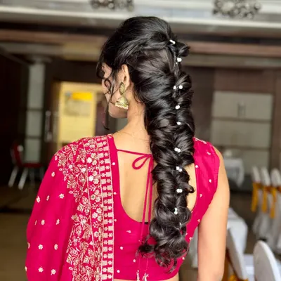 Letting the hair flow like ocean waves. This stunning and intricate mermaid braid, adorned with small pearls, is a perfect statement hairstyle for a lehenga or gown.