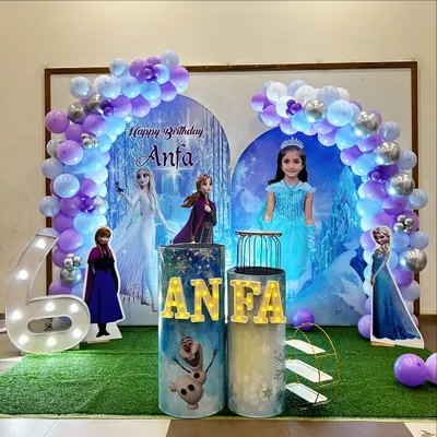 A complete Frozen-themed birthday party setup for Anfa's 6th birthday. It features character cutouts of Elsa, Anna, and Olaf, custom-printed pedestals, a light-up marquee number '6', and a balloon arch in shades of purple, blue, and silver.