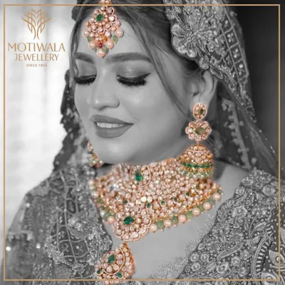 A vision of bridal splendor. This complete bridal set, featuring a magnificent choker, matching earrings, and maang tikka, is crafted with uncut Polki diamonds and vibrant emeralds, embodying the grandeur of traditional Indian weddings.