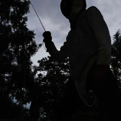 A lone fencer stands in a powerful 'en garde' stance, their foil pointed towards the sky. This silhouette captures the solitary focus and determination required to excel.