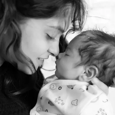 A tender black and white moment between a mother and her newborn baby. This style emphasizes the emotional connection.