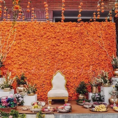 You can never go wrong with marigolds for a Haldi ceremony. I created this magnificent backdrop made entirely of bright orange marigolds, complemented by traditional brass pots and a classic white throne for the bride.