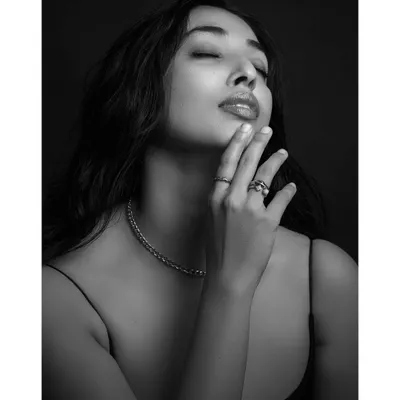A black and white portrait that focuses on emotion and texture. The close-up on the model's face and the delicate jewelry creates a sense of intimacy and timeless beauty.
