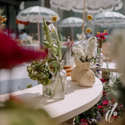 A close-up of the floral details from a spring luncheon. We used a mix of wildflowers in simple glass and ceramic vases, creating a look that is effortlessly chic and full of natural beauty.