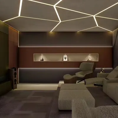 A modern home theater with geometric LED ceiling lights and comfortable recliner chairs. The design focuses on creating an immersive atmosphere with dark walls and ambient lighting.