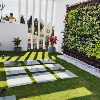 This terrace in Rammurthy Nagar shows how we combine different elements. We installed a natural lawn with stepping stones alongside a full vertical garden, creating a functional and beautiful outdoor living area.