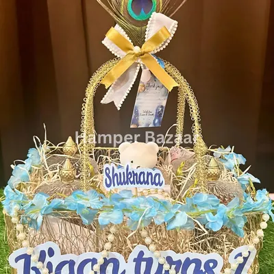 A close up of a personalized birthday return hamper for Kian's first birthday. We used a 'Shukrana' theme with peacock feathers to add a touch of grace and gratitude.