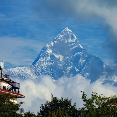 The majestic peak of Machapuchare, or Fishtail Mountain, piercing through the clouds. This is a view that greets our trekkers on the Annapurna Base Camp trail, a constant and inspiring companion.