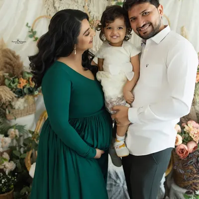 A happy family portrait in our cozy, boho-inspired studio setup. This image captures the joy of a growing family, with everyone smiling and embracing in a relaxed, natural way.
