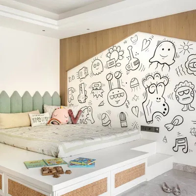 This kids' room at Noor Haus is a world of imagination. We designed a raised platform bed with integrated storage and a playful house-shaped cutout behind it, which we had hand-painted with whimsical doodles.