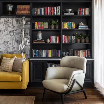 This cozy reading corner in the Magnolia project is a perfect example of layered design. A dark, built-in bookshelf creates a dramatic backdrop for a sculptural armchair from our Koko collection, while playful wallpaper adds a touch of the unexpected, creating a space that feels both curated and deeply personal.