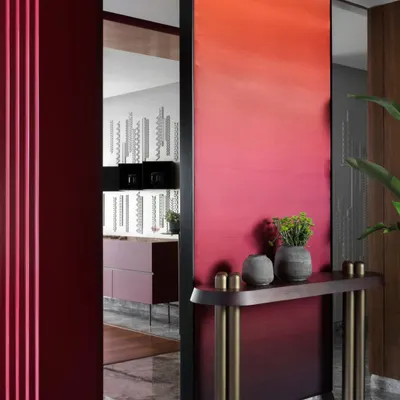 The entrance to the Scarlet Horizon living area is framed by a bold, ombré-painted partition, creating a powerful visual transition. This design choice was a daring departure from safer palettes, reflecting the unique and vibrant personality of the homeowners.