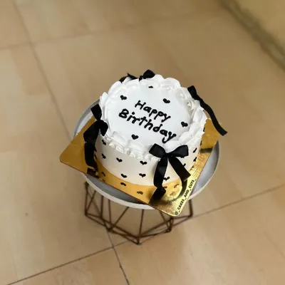 A cute and simple vintage-style bento cake with black bows and hearts, perfect for a small celebration.