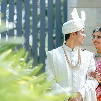 A classic, romantic portrait of a couple. The groom looks lovingly at his bride, who smiles back, her hand resting gently on his arm. A timeless capture.