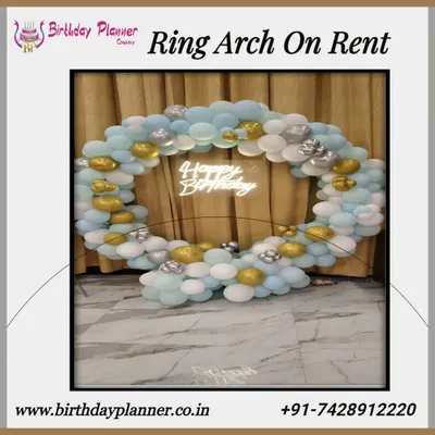 Our ring arch rentals are a popular choice for creating a stunning photo backdrop. This example shows a circular frame decorated with blue, white, and gold balloons, complete with a "Happy Birthday" neon sign for a birthday party.