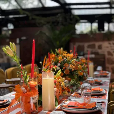 An elegant table setting for the Hermès-themed baby shower, with a long floral runner, tapered candles, and custom place settings.