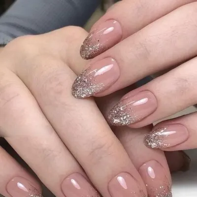 A beautiful and elegant design featuring a sheer nude base with a sparkling gold glitter gradient starting from the tips.