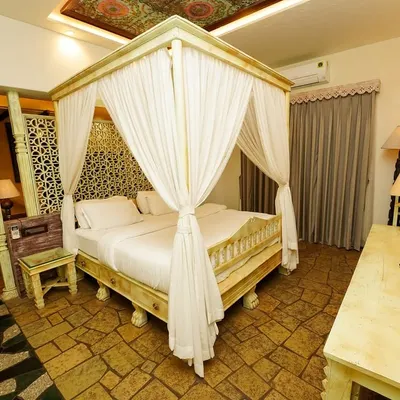 A four-poster canopy bed serves as the centerpiece of this vintage-style luxury suite. My composition highlights the room's romantic and classic design, making it stand out.