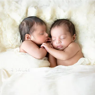 A quiet, tender moment between newborn twins. I use a simple, soft white blanket to create a cloud-like bed, ensuring the focus remains on their peaceful sleep and connection.