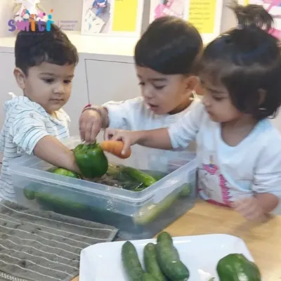Our toddlers joyfully wash vegetables for a salad. This practical life activity introduces them to food preparation and the importance of cleanliness in a playful, sensory-rich way.