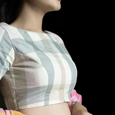 Elevate your ethnic wardrobe with this pure cotton blouse in a subtle check pattern. The boat neck and elbow-length sleeves offer a flattering silhouette, while the front zipper adds a modern, practical touch.