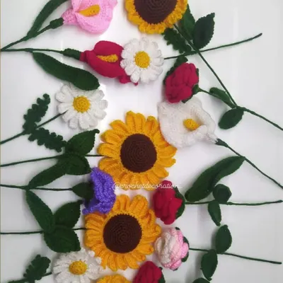 A beautiful flat lay of our various single crochet flower stems. You can see sunflowers, daisies, calla lilies, and roses, ready to be mixed and matched into a custom bouquet.