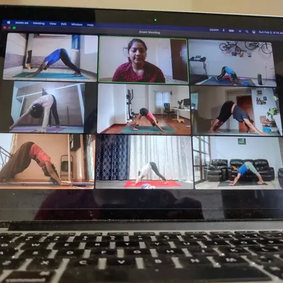This is what my virtual corporate wellness programs look like. I lead the class live via Zoom, allowing me to see everyone and offer personalized guidance, just like in an in-person session. Here, the team is moving into Adho Mukha Svanasana, or Downward-Facing Dog.