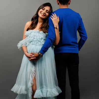The connection between partners during this time is so special. Here, she leans on him for support, a quiet and powerful pose that speaks volumes about their shared journey. This shot, part of a session with our popular light blue gown, shows the tender side of couple maternity photography.