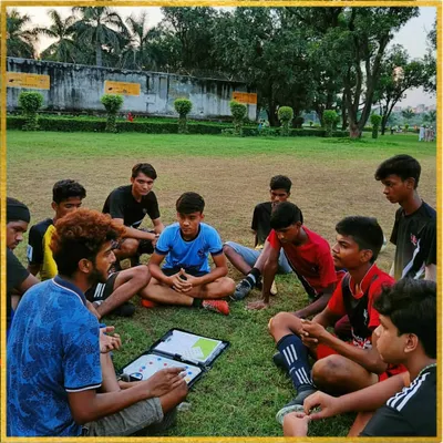 A huddle with the tactical board. This is where we break down game plans, discuss player roles, and analyze formations. It's a crucial part of our youth football coaching program.