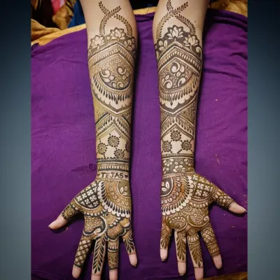 A close-up of the bridal mehandi for Tejas's bride, with his name beautifully integrated into the design on her wrist.