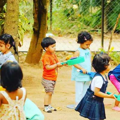 Young children explore different sports props, learning through discovery. Holding and using equipment like these foam bats helps them develop grip strength and curiosity about new sports.