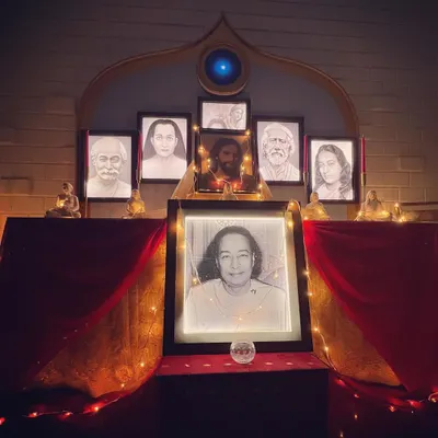 Our altar, illuminated by soft lights for an evening meditation. The portraits of the masters create a powerful focal point, helping to elevate the consciousness of all who gather here.