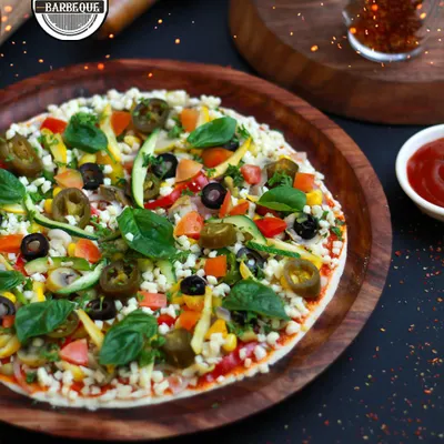 A slice of happiness, made to order. This is our freshly prepared vegetable pizza, loaded with jalapeños, olives, corn, and basil, straight from our live pizza station.