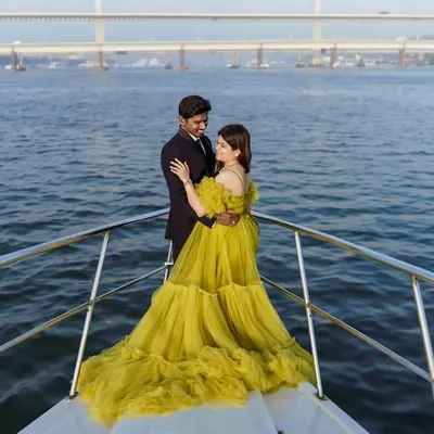 A breathtaking view of our lime green ball gown on a yacht, with the city bridge in the background. This is the ultimate luxury maternity shoot experience.