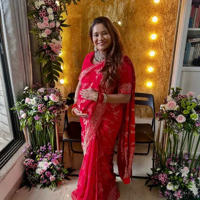 A moment from my own baby shower, feeling all the love and blessings. I chose a soft, radiant makeup look to go with my red saree, keeping it comfortable and glowing.
