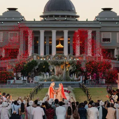 A shower of crimson petals rains down as the couple exchanges garlands. I orchestrate these pivotal moments with dramatic flair, ensuring the Varmala is a visual spectacle that matches the grandeur of the venue.