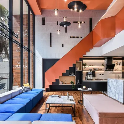 The heart of the Venus Communiti coworking space. The combination of a striking orange staircase, double-height ceilings, and a mix of comfortable lounge furniture creates an impressive and functional central hub for members.