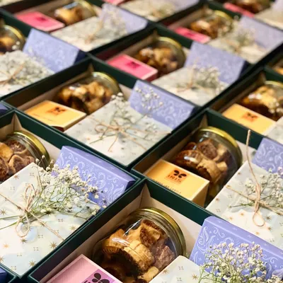 We curated these beautiful hampers for a wedding invitation, combining sweet and savory treats with the lovely fragrance of a scented candle. Each box contains chocolates, choco almonds, cookies, and a candle.