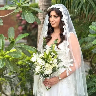 This bride was an absolute vision in her white gown. We opted for soft, romantic waves cascading under a delicate, leaf-patterned veil for a touch of ethereal beauty.